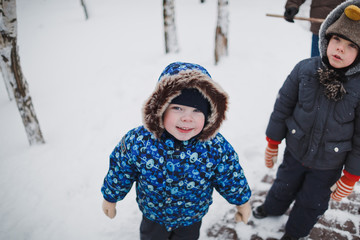 Two small child brothers walking in winter outdoors. Frost winter season.