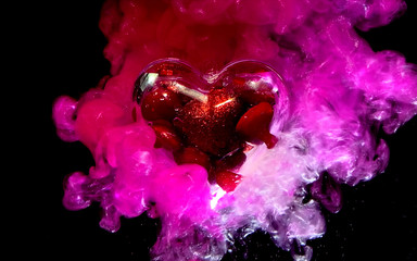 Beautiful glass heart with small red shiny hearts inside on a beautiful red-pink background.