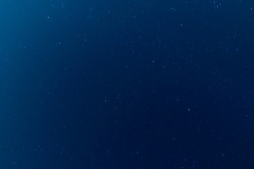 Moving stars at night, dark blue sky background. Long exposure shot. 