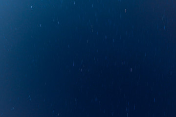 View to the moving stars at night, dark blue sky background. Long exposure shot. 