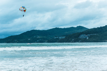 Thailand - July, 2019: skydiver flies through the sky over the  sea Kata beach