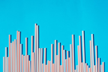 Plastic cocktail straws arranged in columns of statistics graph on a blue background