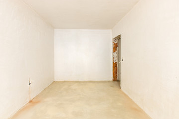 New empty room under construction. Plaster walls. New home. Concrete walls. Interior renovation.