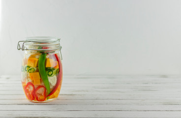 glass jar of fermented vegetables on a light background. fermentation is a source of probiotics