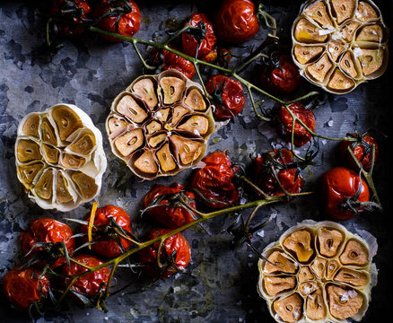 Overhead view of roasted garlic and cherry tomatoes on table