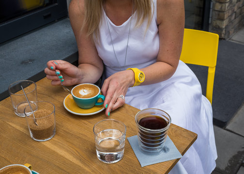 Midsection of woman having coffee outdoors