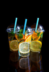 Three glasses of lemonade isolated on a black background.