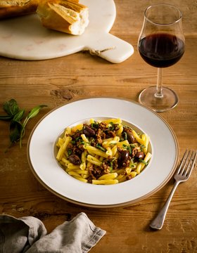 Pasta served with wine and bread on table