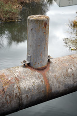 Close Up of Weathered & Rusty Steel Pipe Spanning a Canal