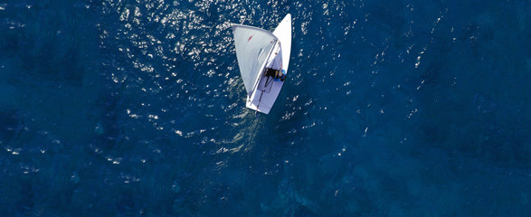 Aerial drone ultra wide photo of children practising with small sail boats in Mediterranean bay with deep blue sea