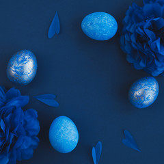 Blue easter eggs ombre and paper flowers on dark background. Easter stylish minimal composition....
