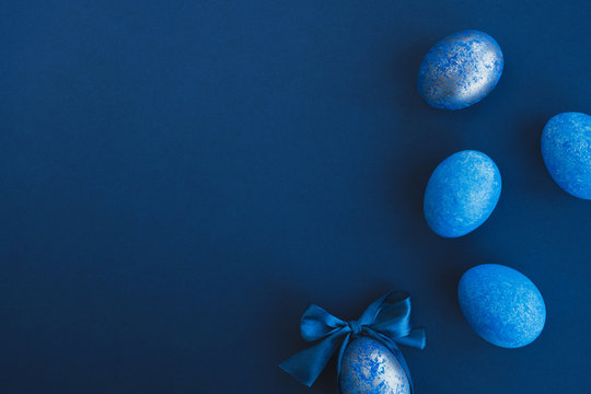 Blue easter eggs painted by hand on a dark background. Easter stylish minimal composition. Top view, flat lay, copy space