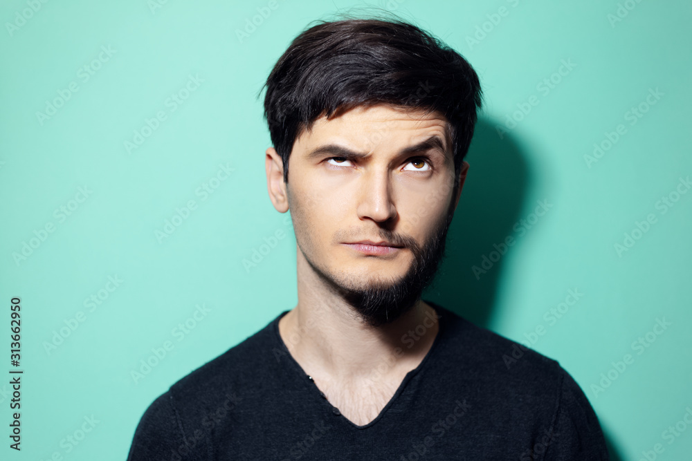 Canvas Prints Studio portrait of young man with half shaved face looking up on background of aqua menthe color.