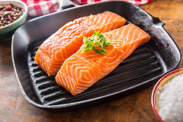 Fresh raw salmon fillets served in cast iron grill pan