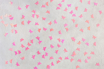 Neon Pink butterflies glitter on the white concrete background.