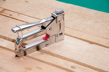 Furniture stapler closeup on wooden background. Furniture maker tool