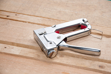 Furniture stapler closeup on wooden background. Furniture maker tool