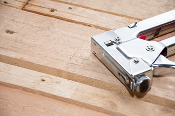 Furniture stapler closeup on wooden background. Furniture maker tool