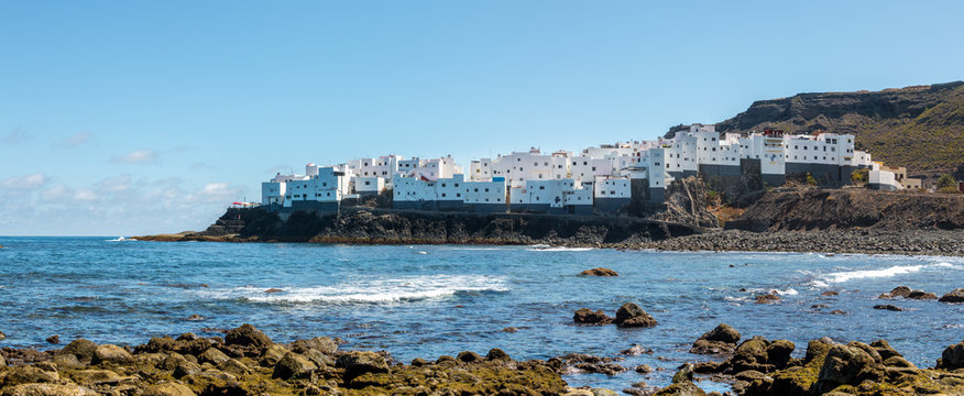White house neighborhood facing the sea with rocky beach in foreground