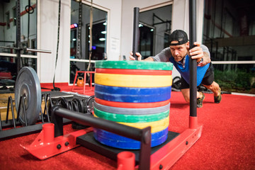 Man pushing weight sled at the gym