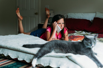 Tween Girl Talking on the Phone in a Bedroom