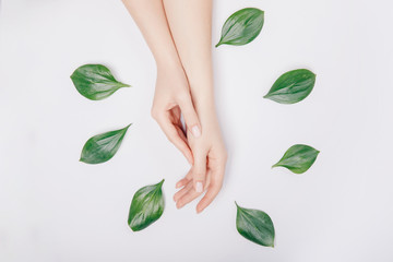 Concept bio nature cosmetics skin care. Beautiful stylish trendy female pink manicure with flower on background, top view