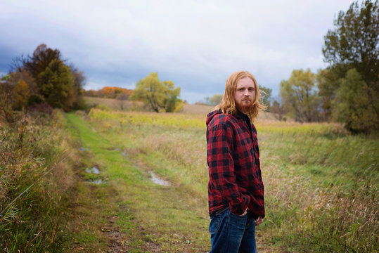 Young Man With Long Red Hair and Beard Outside in the Country