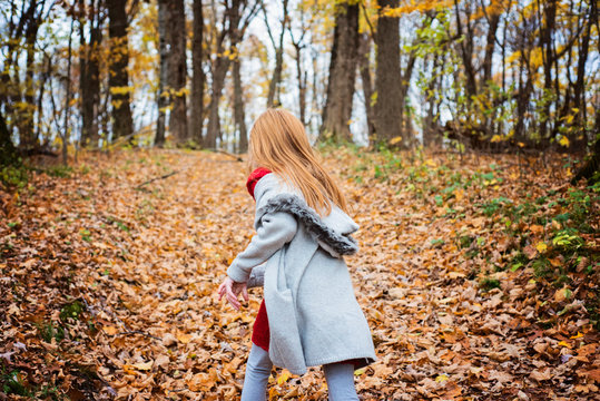 Young Red Hair Girl Playing Outside in Fall Leaves