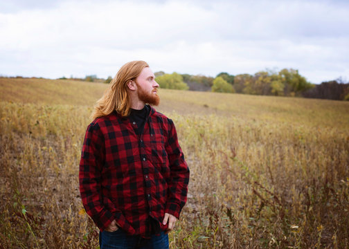 Young Man With Long Red Hair and Beard Outside in the Country
