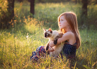 Young Girl With Kitten Outdoors in Meadow