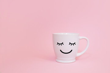 Happy friday word. Cup of coffee on pink background with smile face on mug.