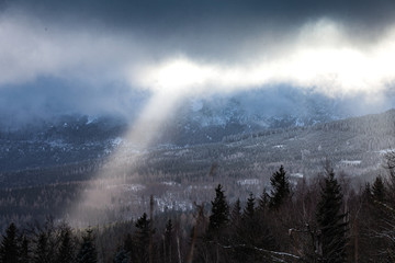 Promienie słoneczne przbijające się przez chmury w górach