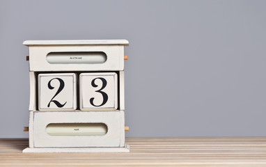 Desktop wooden retro calendar with day number 23. Calendar template for writing a holiday date and free text space