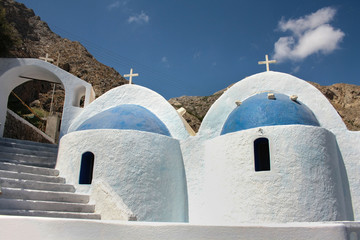 The characteristic white and blue church against the rocky hills of the island of Santorini