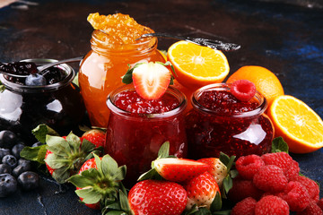 assortment of jams, seasonal berries jelly, mint and fruits and tangerine
