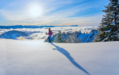 nice senior woman snowshoeing on the Nagelfluh chain above a sea of fog over Bregenz Wald...