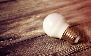 The concept of the idea. Light bulb on a wooden background
