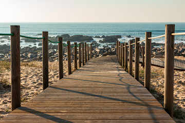 Fototapeta premium wooden fence and walkway to the beach with rocks
