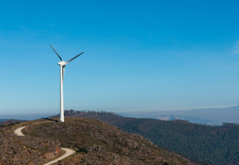 Wind Turbines at Baloi&ccedil;o da Boneca in Portugal Mountain region with mist blue sky in the background