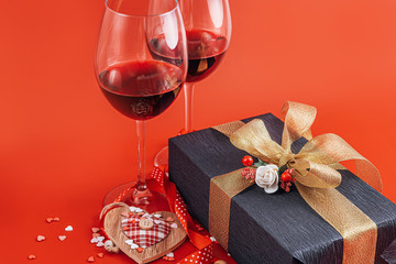 two glasses of wine and a gift in a luxurious box