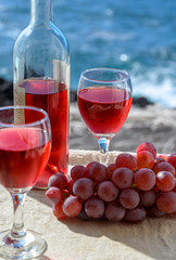 Two glasses of rose wine served outdoor with pink grapes fruits on tropical island La Palma, Canary islands, Spain with beautiful blue ocean view