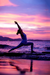 Woman practices yoga at seashore