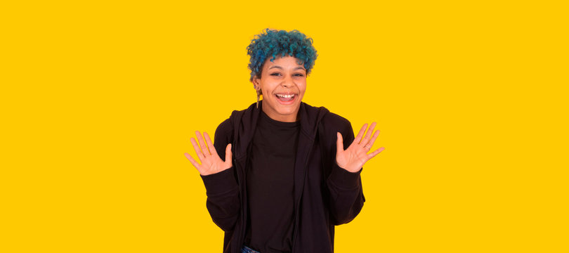 young african american girl or woman with blue hair isolated on yellow background