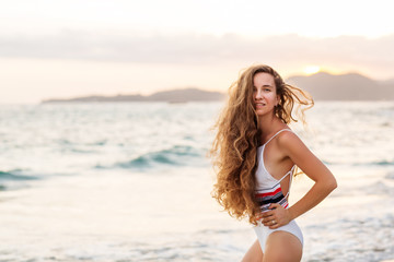 Beautiful girl on the ocean at sunset