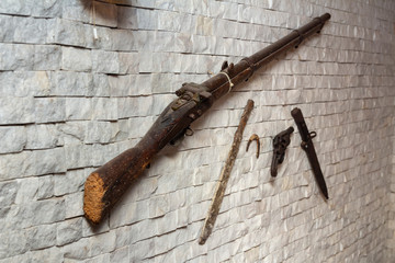 old gun and knife on the wall