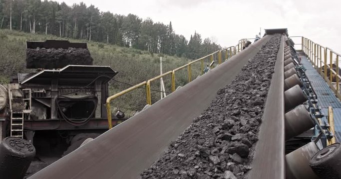 Conveyor belt with coal shooting in slow motion. Close-up there is coal on belt conveyor. Conveyor belt coal. Machine for loading mining in coal obage factory