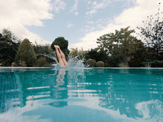 Obraz na płótnie Canvas Slender girl dives into the pool