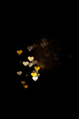 Abstract light, golden bokeh pattern in heart shape. St Valentides Day or Holiday concept, background image.