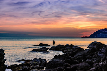 Man on rocks fishing in the sea