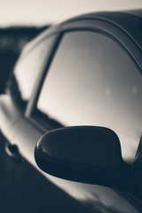 Close up moody stylised black and white shot of a car window.